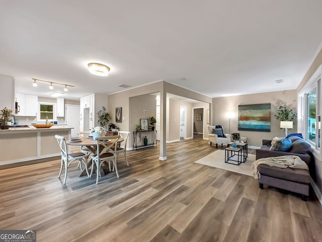 dining space featuring light wood-style flooring, baseboards, and visible vents