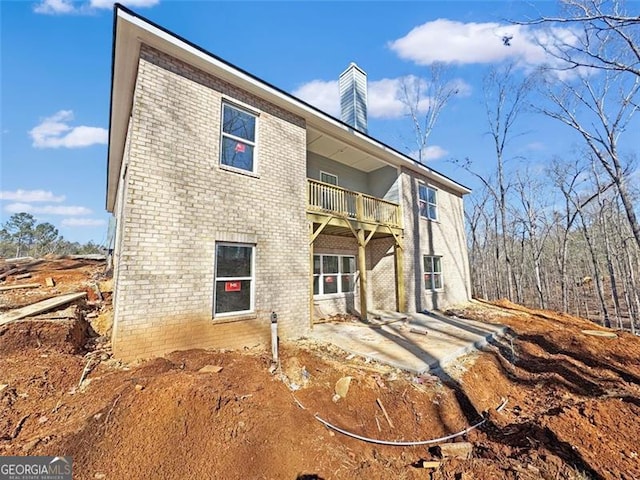 back of property with a balcony and a patio