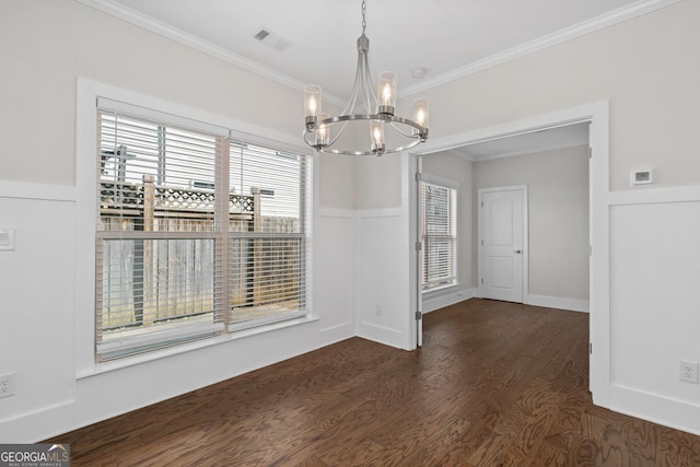 unfurnished dining area featuring dark hardwood / wood-style floors, crown molding, and a notable chandelier