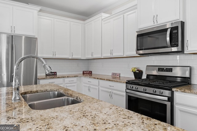 kitchen featuring stainless steel appliances, white cabinets, tasteful backsplash, and sink