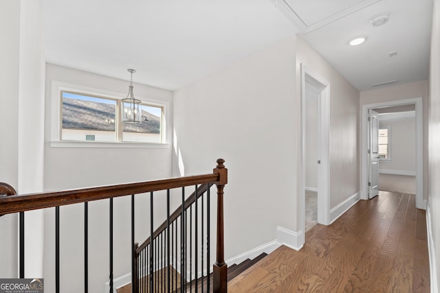 hallway featuring hardwood / wood-style floors, plenty of natural light, and a notable chandelier