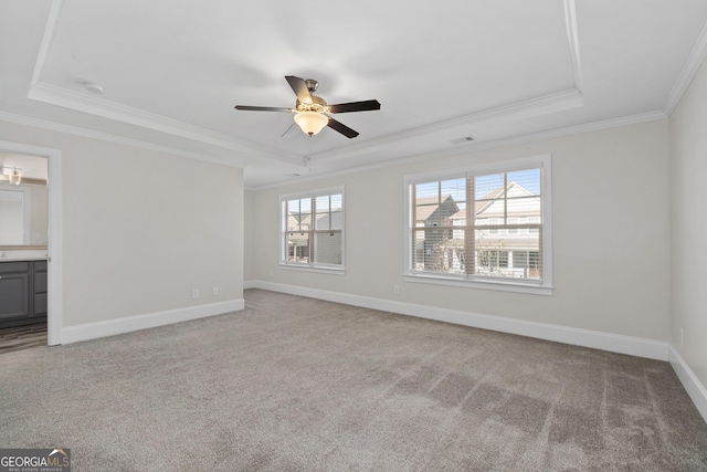 carpeted empty room with ceiling fan, a tray ceiling, and crown molding