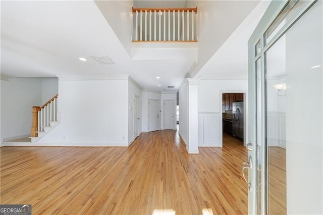 entrance foyer with crown molding and light wood-type flooring