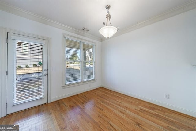 unfurnished dining area featuring a wealth of natural light, crown molding, and light wood-type flooring