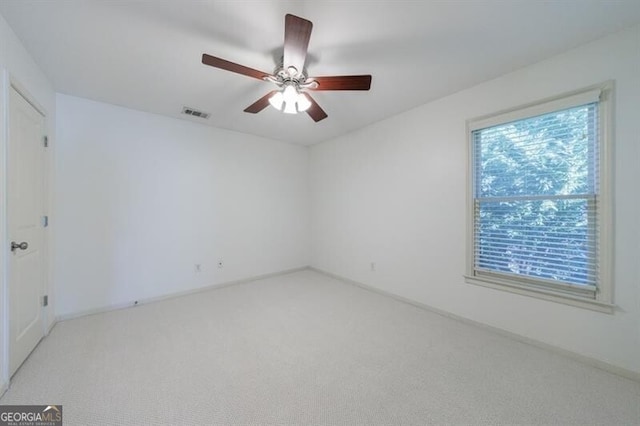 carpeted spare room with ceiling fan