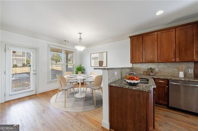 kitchen with light stone countertops, hanging light fixtures, dishwasher, and ornamental molding