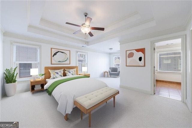 carpeted bedroom with crown molding, multiple windows, ceiling fan, and a raised ceiling