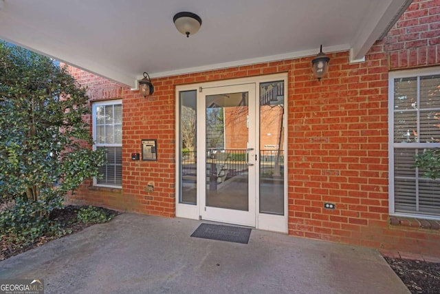 view of exterior entry with french doors and a patio area