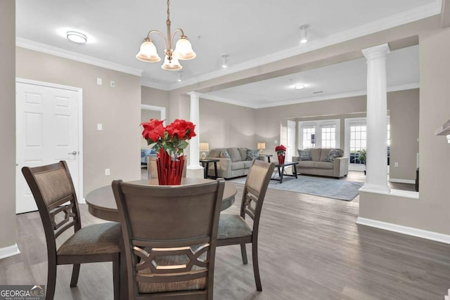 dining space featuring an inviting chandelier, ornamental molding, and decorative columns