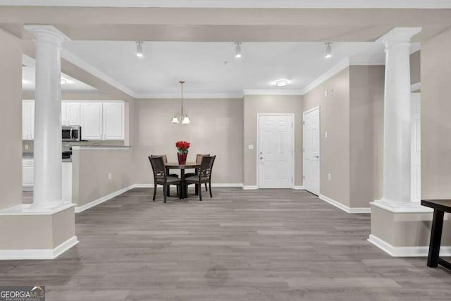 dining area with an inviting chandelier, ornamental molding, and light hardwood / wood-style flooring