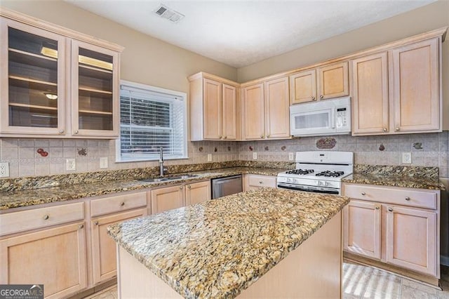 3055 Cooper Woods Ln, Loganville, GA 30052 - kitchen featuring white appliances, light brown cabinetry, light stone countertops, a center island, and decorative backsplash