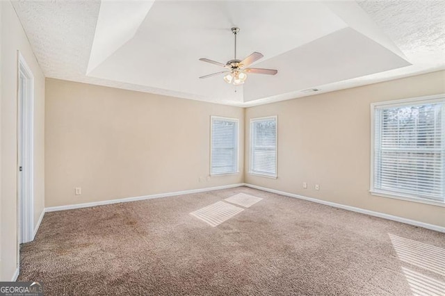 3055 Cooper Woods Ln, Loganville, GA 30052 - empty room with a tray ceiling, ceiling fan, carpet floors, and plenty of natural light