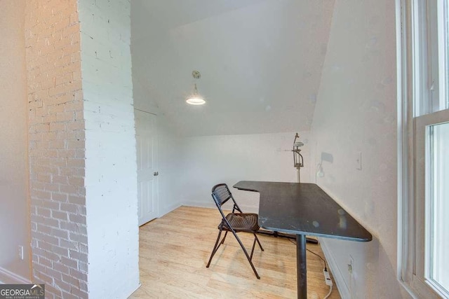 home office featuring lofted ceiling and light hardwood / wood-style flooring