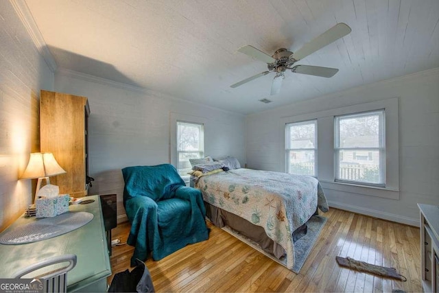 bedroom featuring ceiling fan, ornamental molding, multiple windows, and light hardwood / wood-style floors