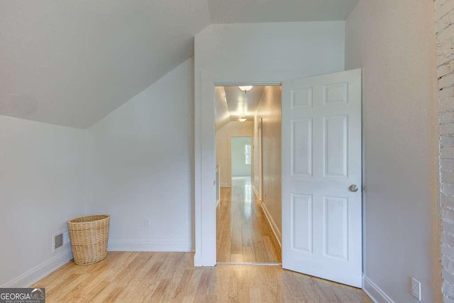 interior space with light wood-type flooring and lofted ceiling