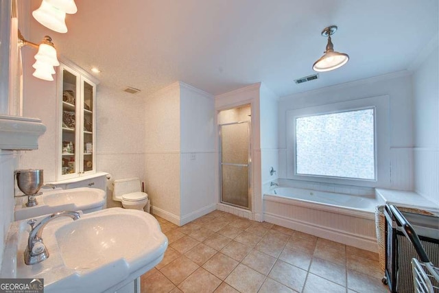 full bathroom featuring tile patterned flooring, shower with separate bathtub, sink, toilet, and ornamental molding