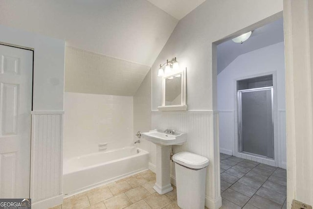 bathroom featuring a tub, lofted ceiling, and tile patterned flooring