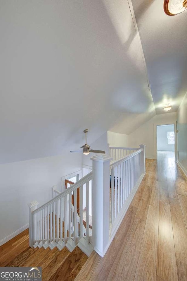 hallway featuring lofted ceiling and light hardwood / wood-style flooring