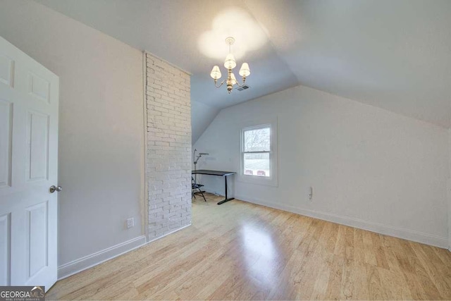 additional living space featuring lofted ceiling, a chandelier, and light hardwood / wood-style flooring