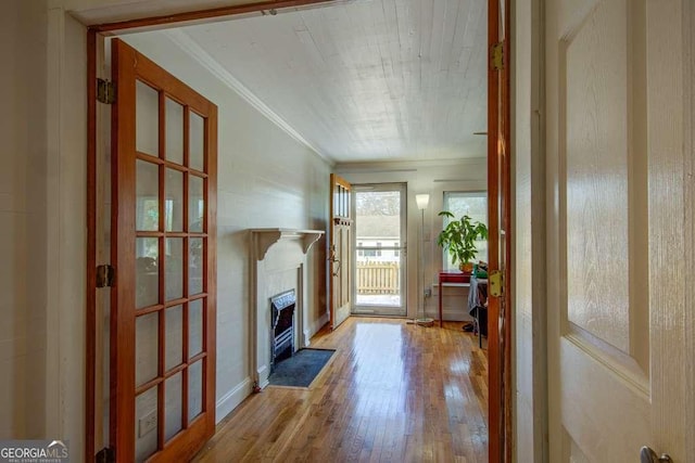 doorway featuring light wood-type flooring and crown molding