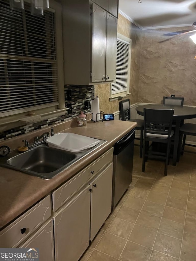 kitchen featuring tasteful backsplash, ornamental molding, a ceiling fan, a sink, and dishwasher