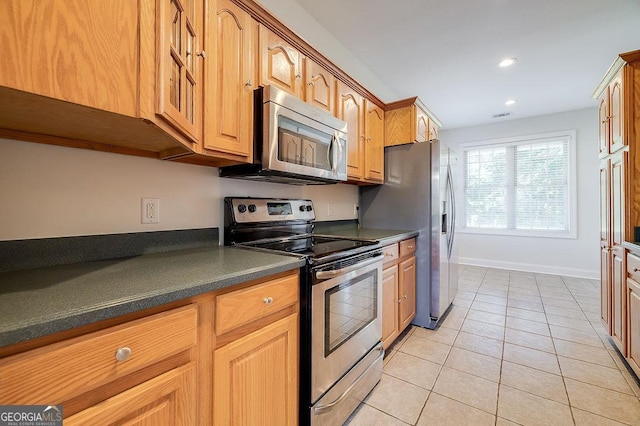 kitchen featuring light tile patterned flooring and stainless steel appliances