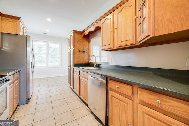 kitchen featuring range with electric cooktop, plenty of natural light, light tile patterned flooring, stainless steel dishwasher, and sink