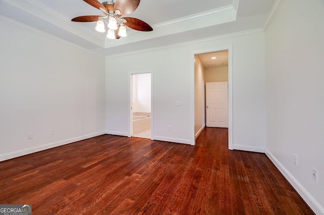 unfurnished bedroom featuring ceiling fan, dark hardwood / wood-style flooring, a raised ceiling, and ensuite bath