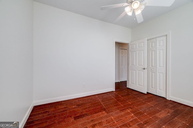 unfurnished bedroom with ceiling fan, a closet, and dark wood-type flooring