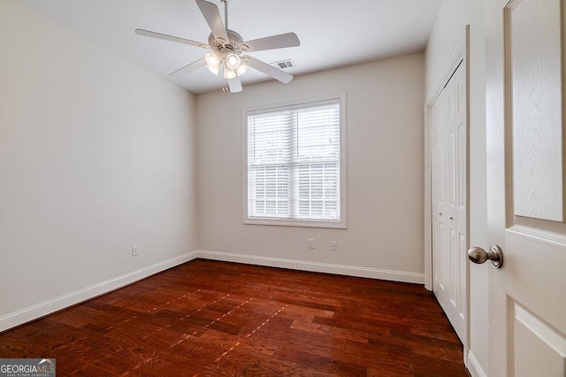 empty room featuring ceiling fan and dark wood-type flooring