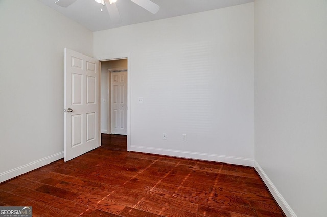 empty room featuring ceiling fan and dark wood-type flooring