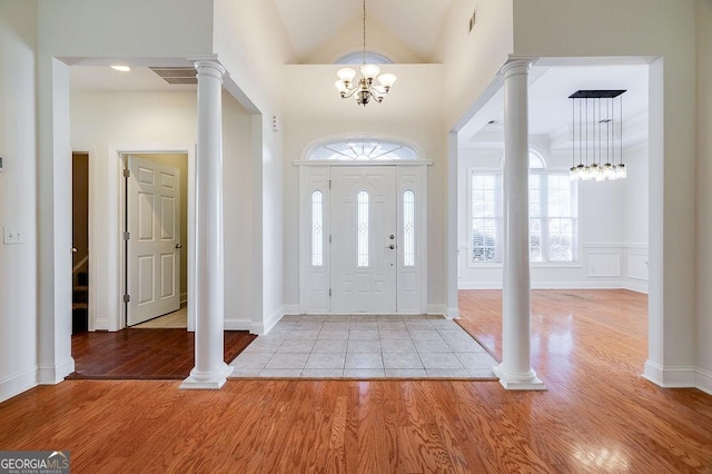 entrance foyer featuring high vaulted ceiling, light hardwood / wood-style flooring, and an inviting chandelier