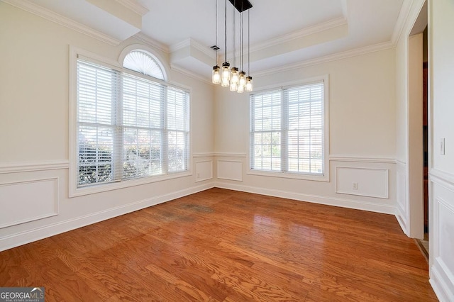 spare room featuring a chandelier, ornamental molding, and hardwood / wood-style flooring