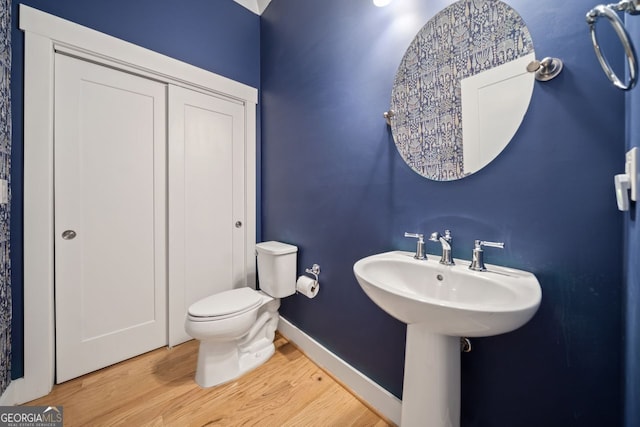 bathroom featuring wood-type flooring, sink, and toilet