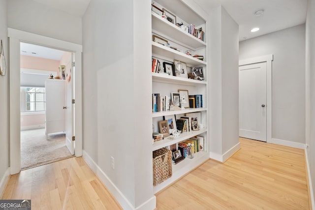 corridor featuring hardwood / wood-style floors and built in features