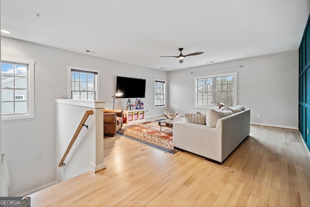 living room featuring ceiling fan, plenty of natural light, and light wood-type flooring