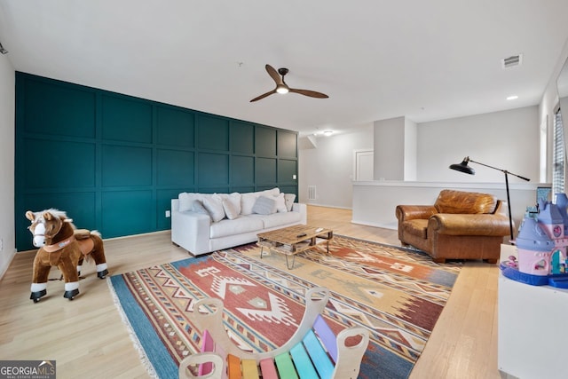 living room featuring ceiling fan and light wood-type flooring