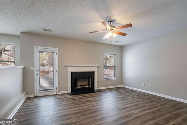 unfurnished living room featuring a textured ceiling, ceiling fan, and dark hardwood / wood-style floors