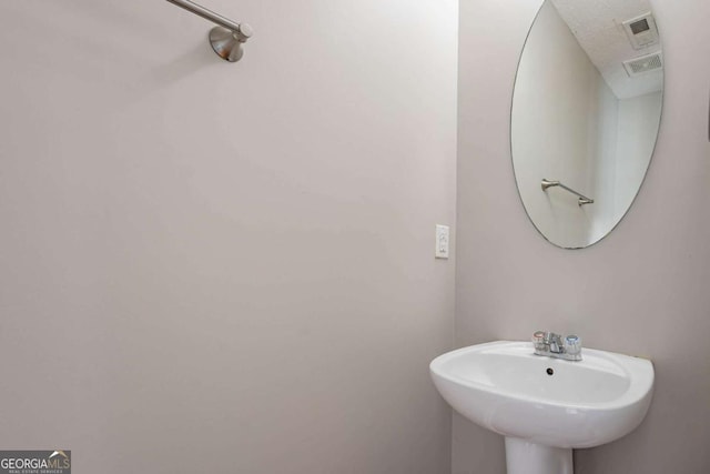 bathroom with sink and a textured ceiling