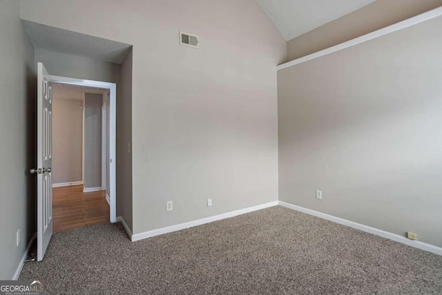 empty room with carpet floors and lofted ceiling