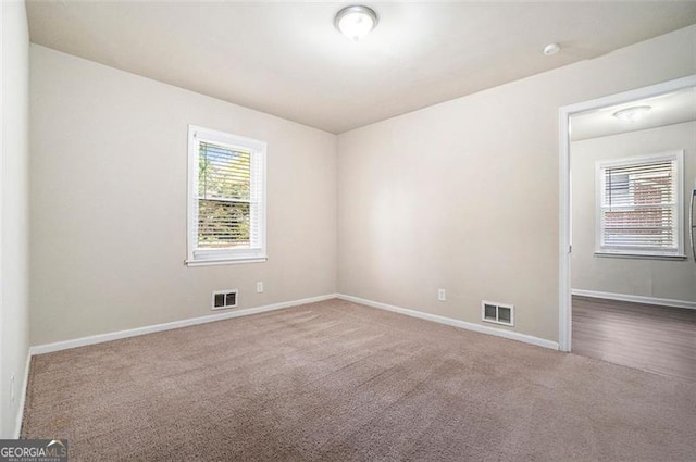 empty room with carpet floors and plenty of natural light