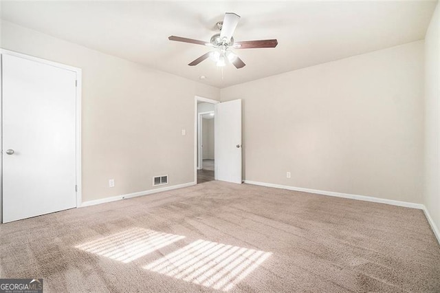 empty room with ceiling fan and carpet