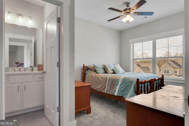 bedroom with light carpet, sink, and ensuite bath