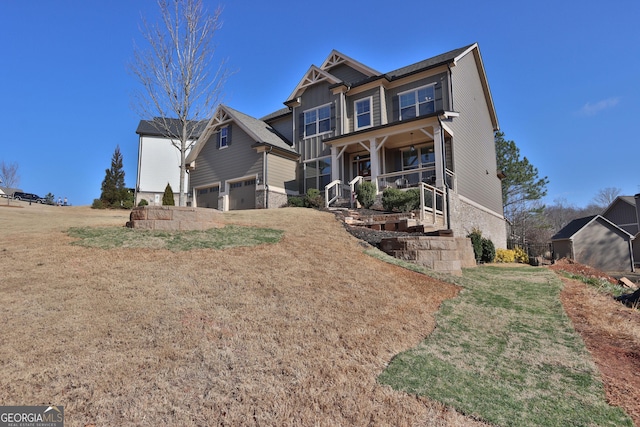 view of front of house with a garage, a front lawn, and a porch