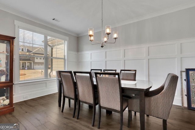 dining area featuring ornamental molding, dark hardwood / wood-style floors, and a chandelier