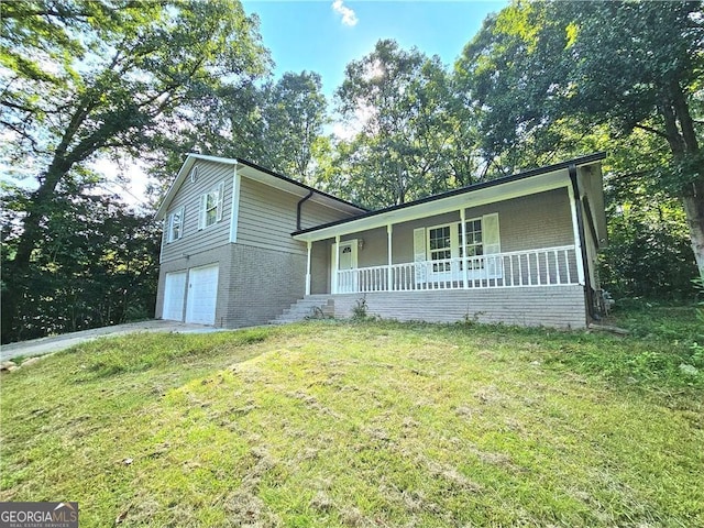 view of front of property featuring a garage, a front yard, and covered porch