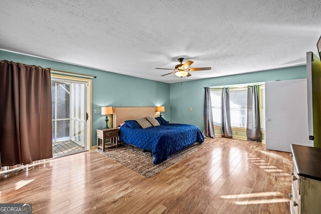 bedroom with ceiling fan, access to outside, a textured ceiling, and light hardwood / wood-style flooring