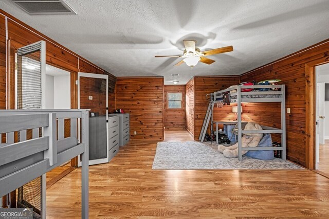 bedroom featuring a textured ceiling, ceiling fan, light hardwood / wood-style flooring, and multiple windows