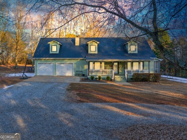 cape cod home with a garage and a porch