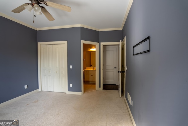 unfurnished bedroom featuring ceiling fan, crown molding, a closet, and light carpet